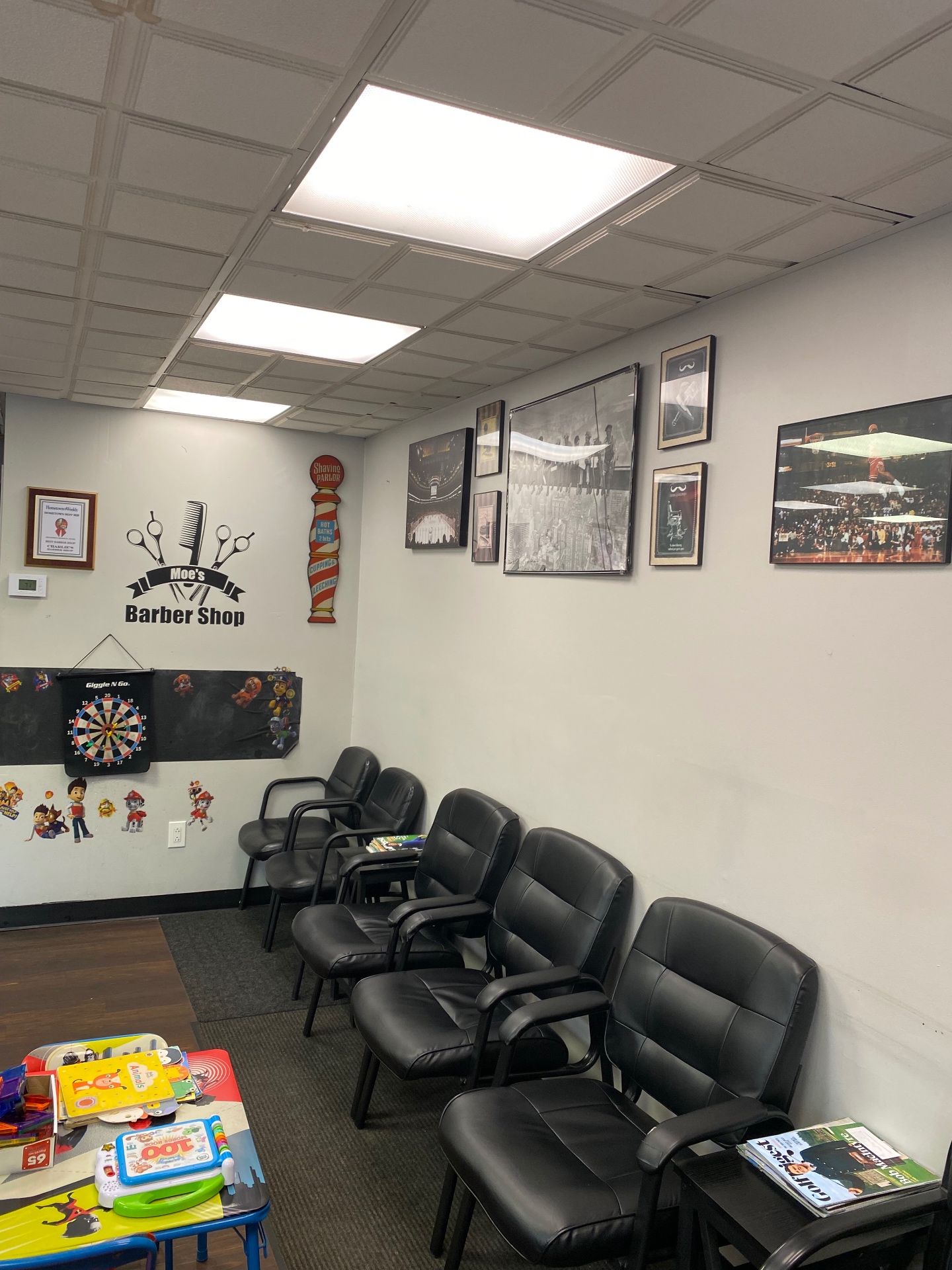 Waiting area with Moe's Barber Shop signage